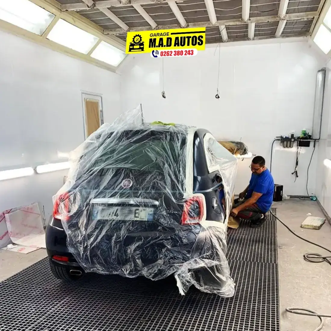 Véhicule masqué dans la cabine de peinture du garage