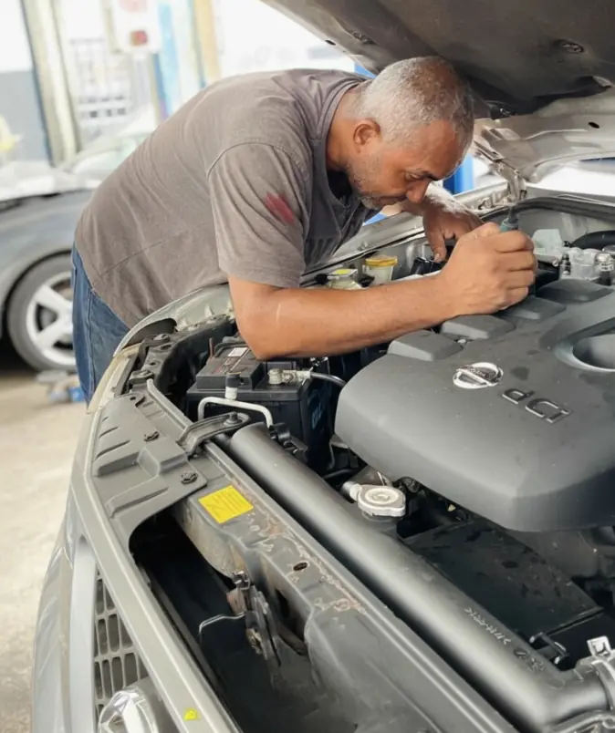 Mécanicien de M.A.D Autos au travail sous le capot d&rsquo;un véhicule